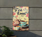 a tea room sign hanging on the side of a building