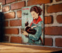 a picture of a woman holding a cat on a brick wall