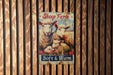 a sheep farm sign hanging on a wooden wall