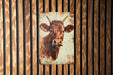a picture of a cow on a wooden wall