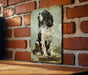 a picture of a dog is hanging on a brick wall