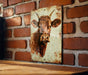 a picture of a cow on a brick wall