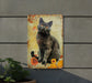 a picture of a black cat sitting on a sign