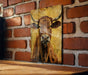 a picture of a cow on a brick wall