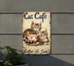 a sign with two cats sitting in a coffee cup