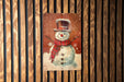 a painting of a snowman on a wooden wall