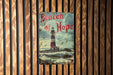 a book on a wooden wall with a lighthouse in the background
