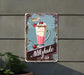 a metal sign that says milkshake bar next to a potted plant