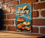 a picture of a bakery sign on a brick wall