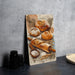 a painting of pastries on a table next to a plate of bread