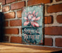 a sign on a brick wall with a flower on it