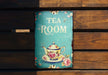 a tea room sign hanging on a wooden wall