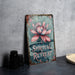 a metal sign with a pink flower on it