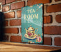 a tea room sign on a brick wall