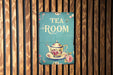 a tea room sign on a wooden wall