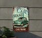 a car wash sign hanging from the side of a building
