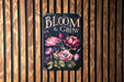 a sign on a wooden wall that says bloom and grow
