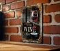 a picture of a glass of wine on a brick wall
