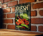 a sign on a brick wall advertising fresh produce