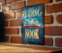 a reading nook sign on a brick wall