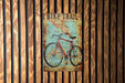 a bike trail sign mounted to a wooden wall