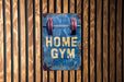 a blue sign that says home gym hanging on a wooden wall