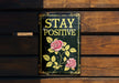 a sign on a wooden bench that says stay positive