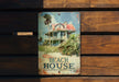 a sign on a wooden wall that says beach house