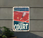 a tennis court sign hanging on the side of a building