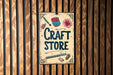 a craft store sign hanging on a wooden wall