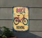 a bicycle rental sign on the side of a building