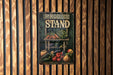 a sign on a wooden wall that says produce stand