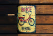a bicycle rental sign on a wooden wall