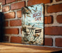 a picture of a beach cafe sign on a brick wall