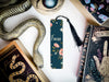 a bookmark with a snake on it next to other books