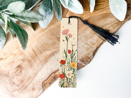 a bookmark with flowers and a tassel hanging from it