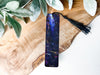 a bookmark with a tassel on top of a piece of wood