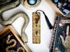 a snake, a bookmark, and other items are on a table