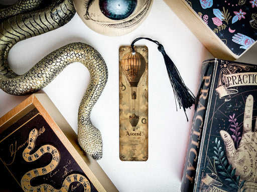 a snake, a bookmark, and other items are on a table