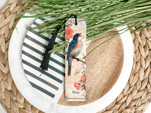 a bookmark with a bird on it sitting on a plate