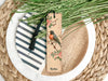 a bookmark with a bird on it sitting on a plate