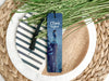 a bookmark sitting on top of a plate next to a plant