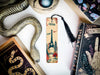 a bookmark with a picture of a city and a snake on it