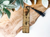 a wooden clock with a tassel hanging from it