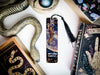 a bookmark with a snake on it next to other books