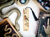 a bookmark with a bird on it next to a snake