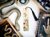 a bookmark with a snake and flowers on it