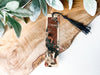 a bookmark sitting on top of a wooden table next to a plant