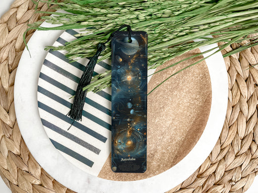 a bookmark sitting on top of a table next to a plant