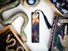 a bookmark with a snake on it next to other books